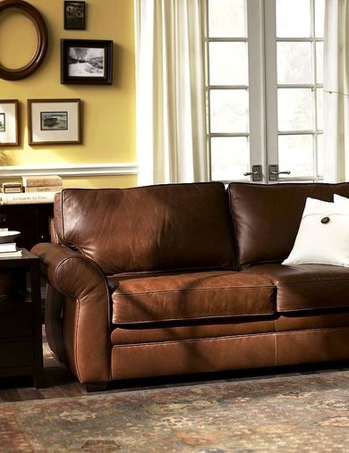 living room with brown leather sofa and yellow goldenrod wall