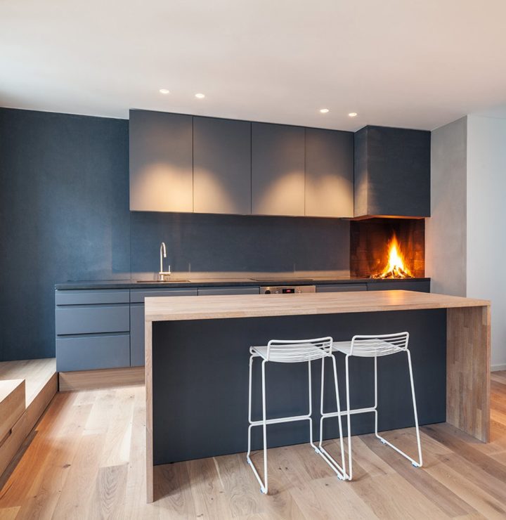 Sleek minimalist black kitchen with island with oak wood worktop